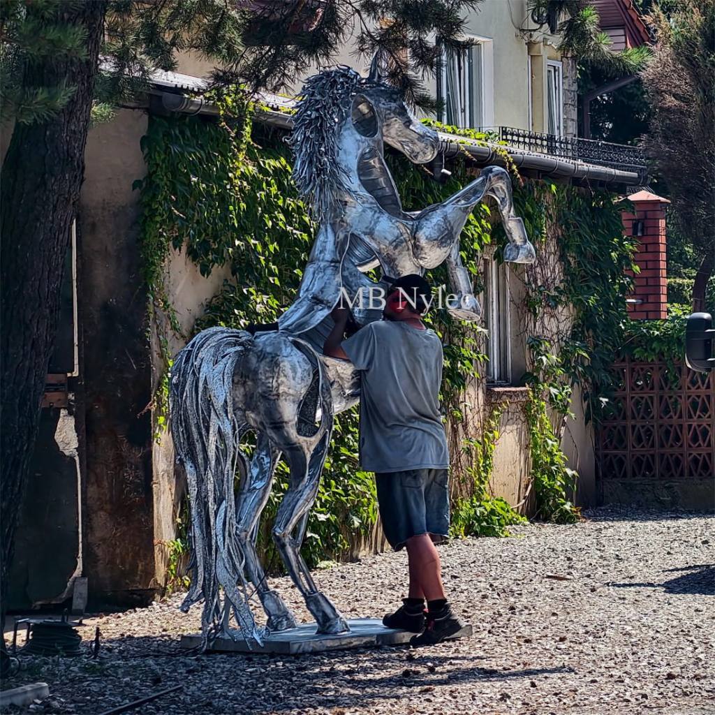 Metal horse sculpture with a person standing beside it for scale