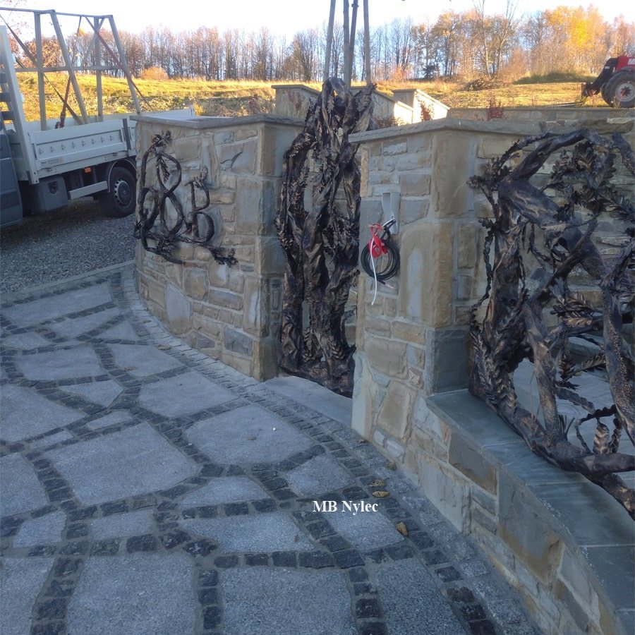 Metal tree wicket gate and sculpted fence on a stone base