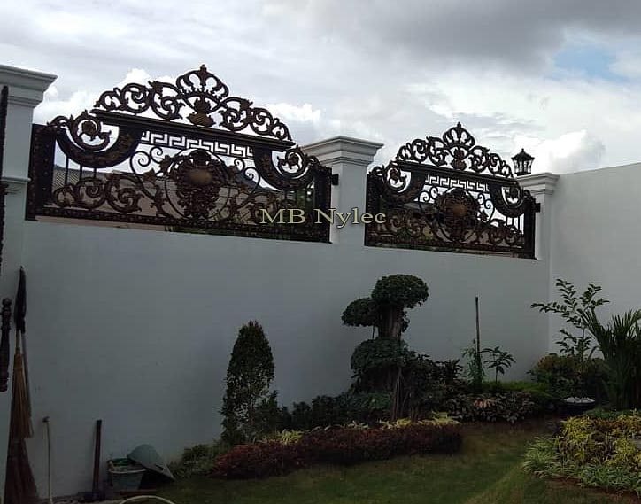 Gilded oriental fence spans BP130B on a white garden wall