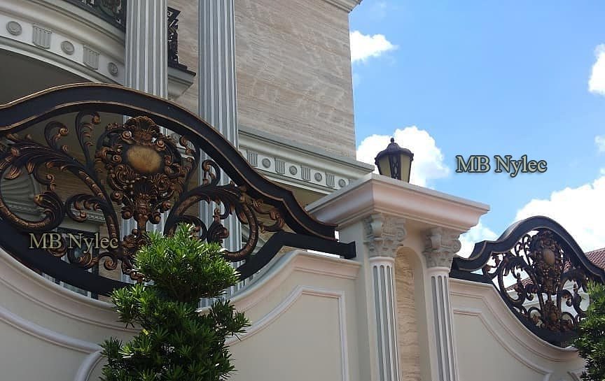Two oriental forged fence panels BP206 with a lantern on the pillar between them