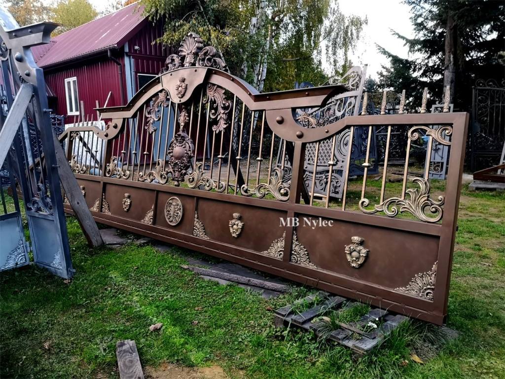 Oriental sliding gate BP99 with a wavy top and medallions on a lawn at our workshop