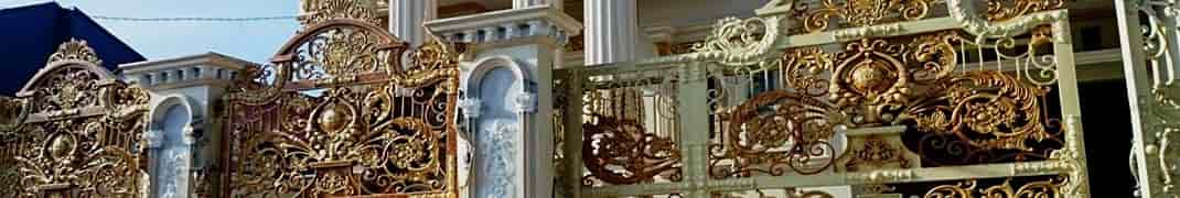 Gilded ornamental wrought iron gate and fence with stone pillars