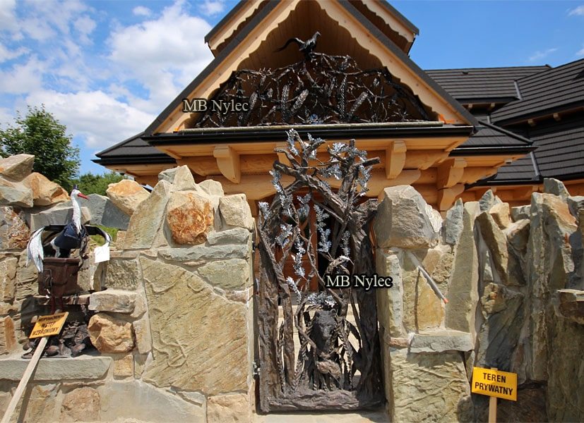 Front of a stone and timber house with the pheasant railing BA85 in the gable