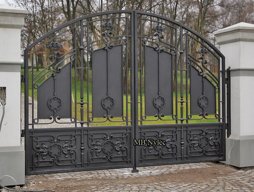 Wrought iron residence gate BP52 with solid upper panels and a scrolled lower band between white pillars