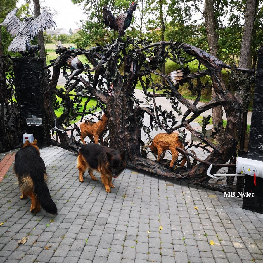 Sculpted metal gate with forged foxes and two dogs in front