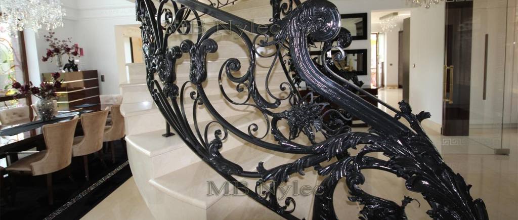 Sculpted newel post of the glamour railing BA5 next to a dining room