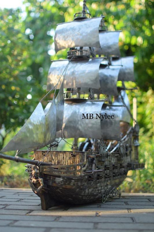 Full-height view of the stainless steel ship Glory with all sails set