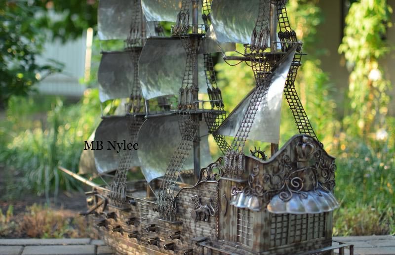 Stern quarter view of the stainless ship Glory against greenery