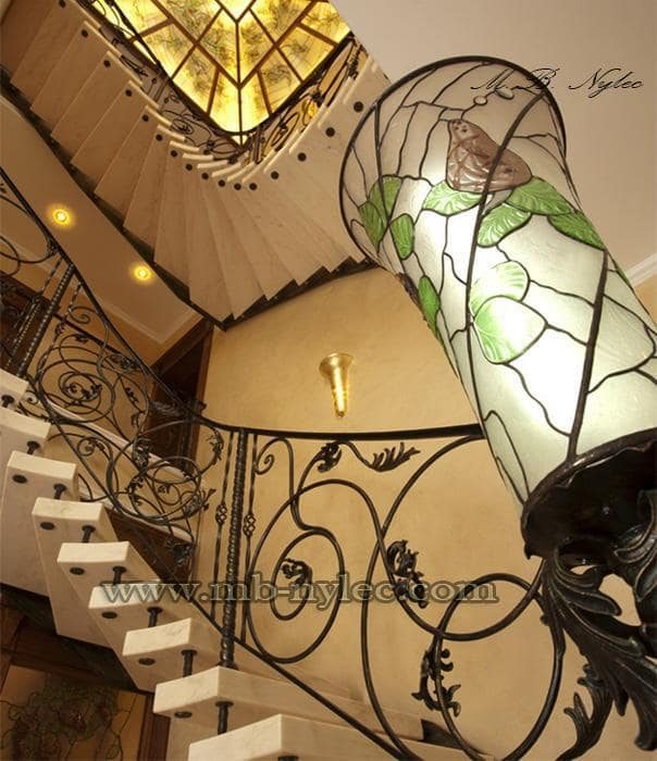 Forged stair railing BA17 with a large stained-glass lamp on the starting post