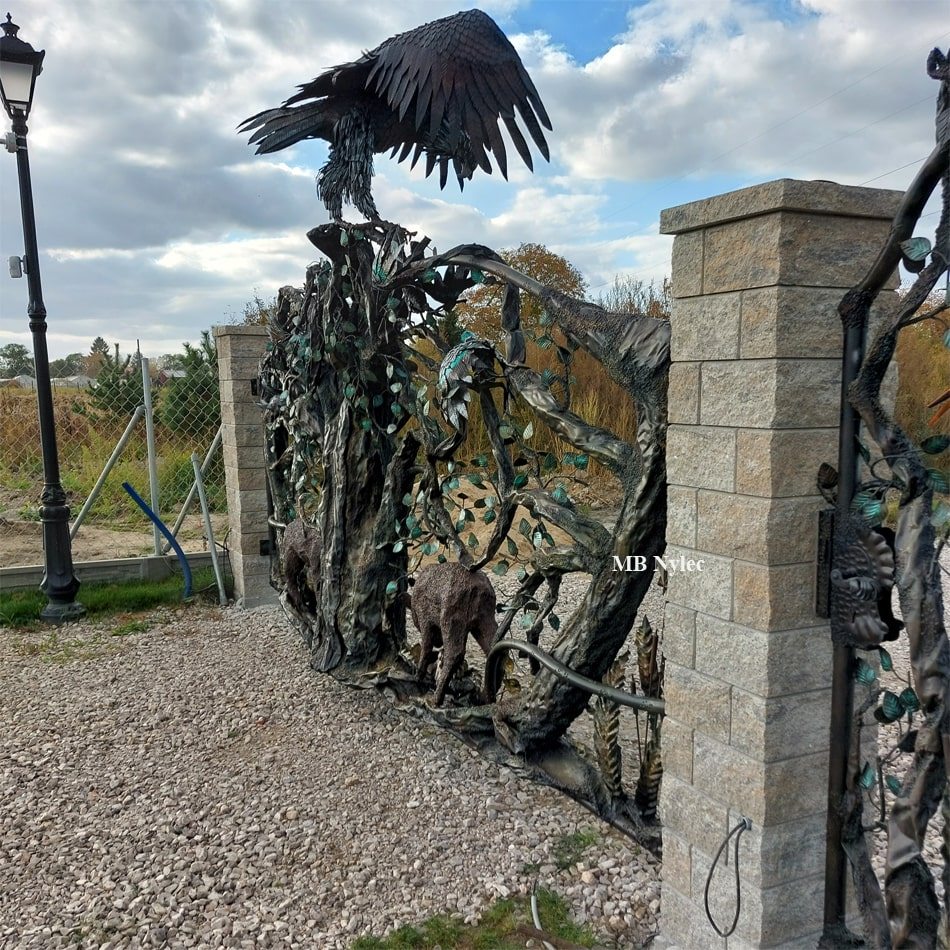 Steel eagle with spread wings on top of a sculpted gate