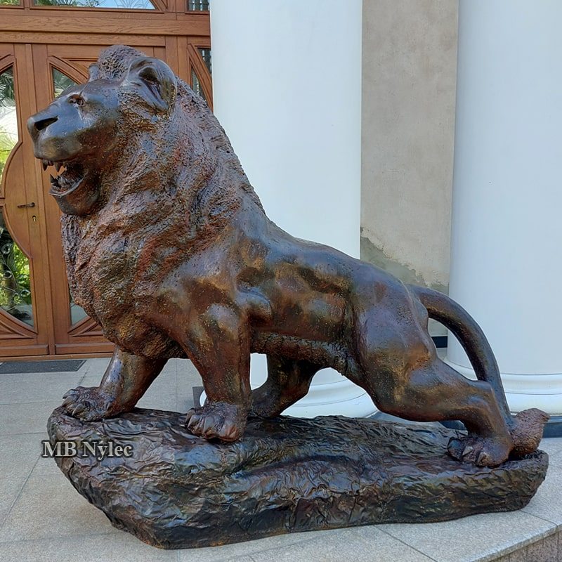 Three-quarter view of the steel lion sculpture Z108 by a front door