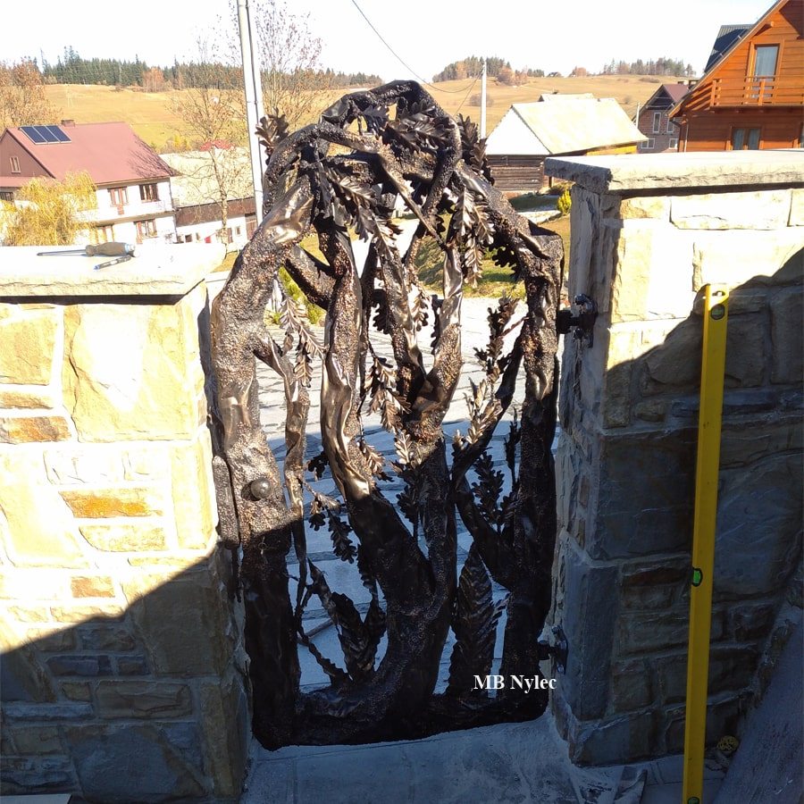 Steel tree garden gate with twisting forged branches and a dense crown