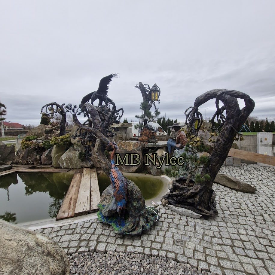 Several steel tree sculptures around a pond in our display garden