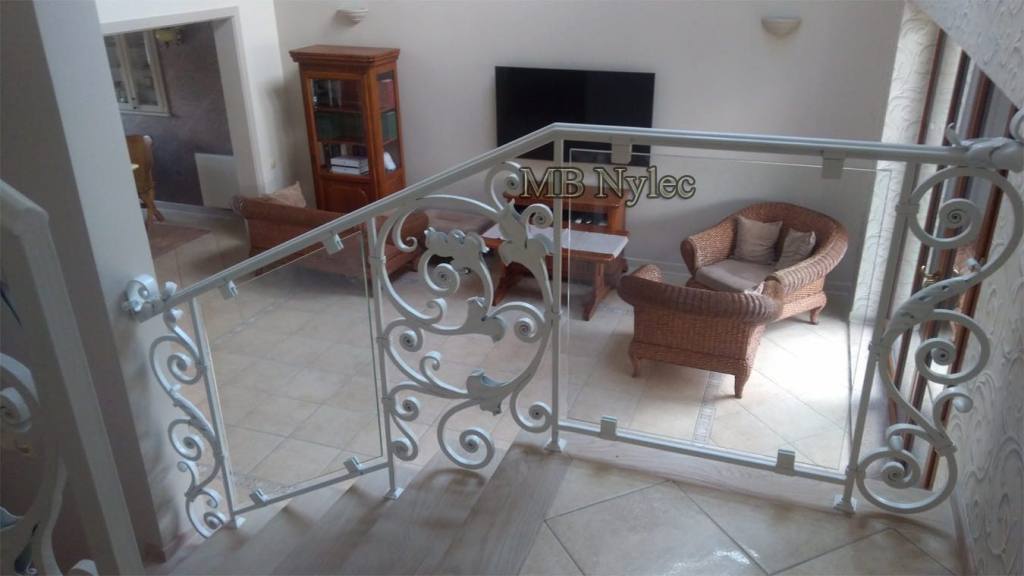 Balustrade BA68 combining white forged scroll panels with clear glass on a stair