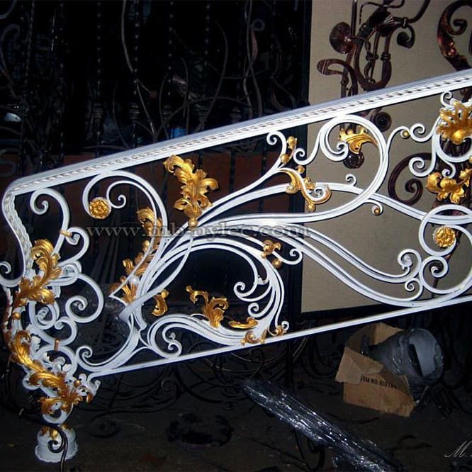 White stair railing panel BA1 with gilded leaves and scrolls before installation