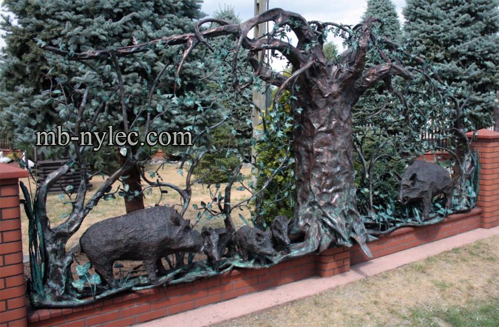 Forged fence span with wild boars beneath an oak tree in a garden